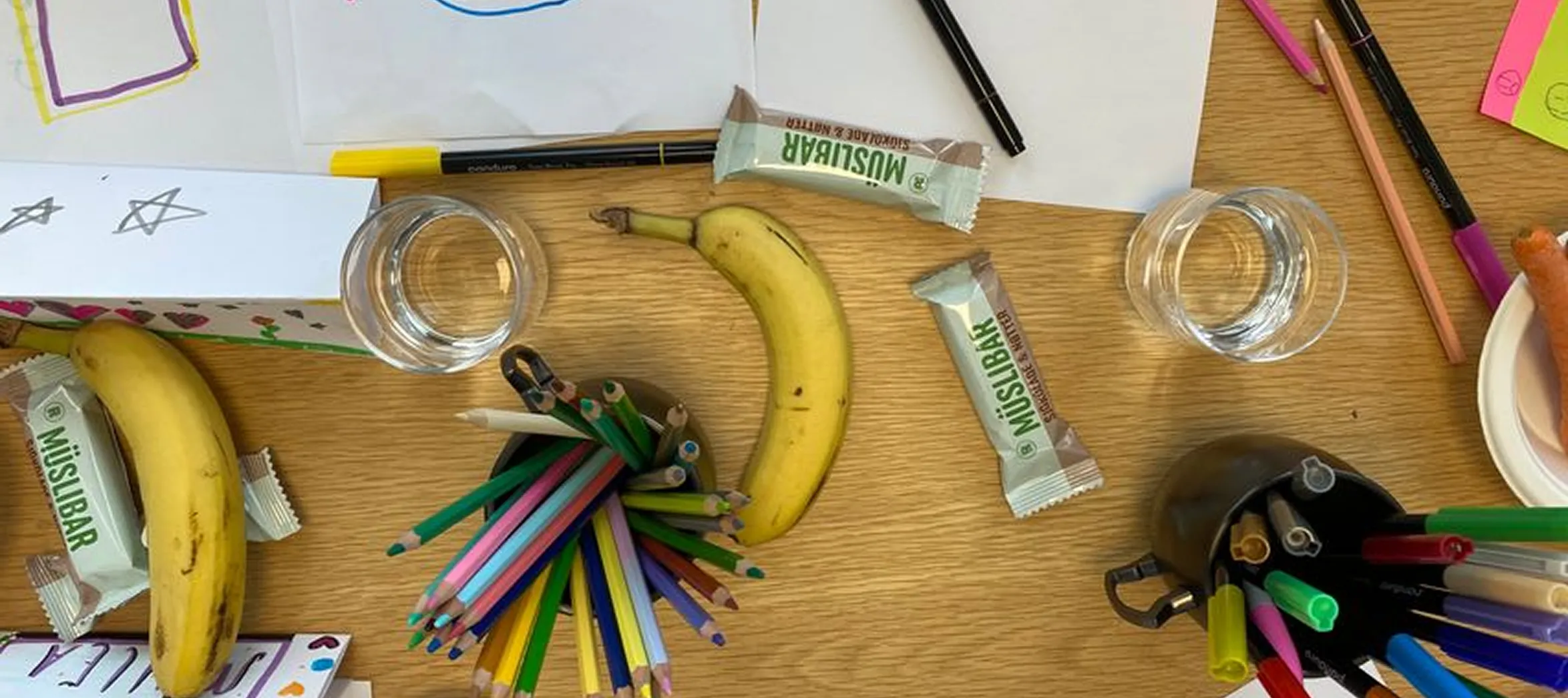 Bordet fra workshopene, dekket med ark, tusjer og barnas kreative forslag til appdesign.